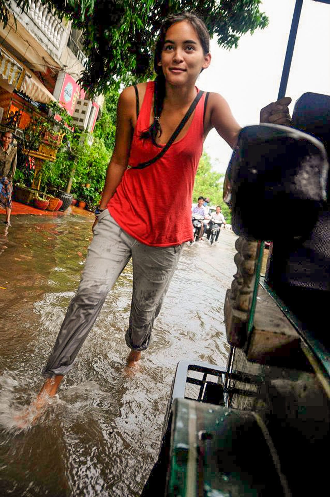 How I afford full-time travel - Pushing a tuktuk through Phom Penh, Cambodia during monsoon - Lost With Purpose travel blog