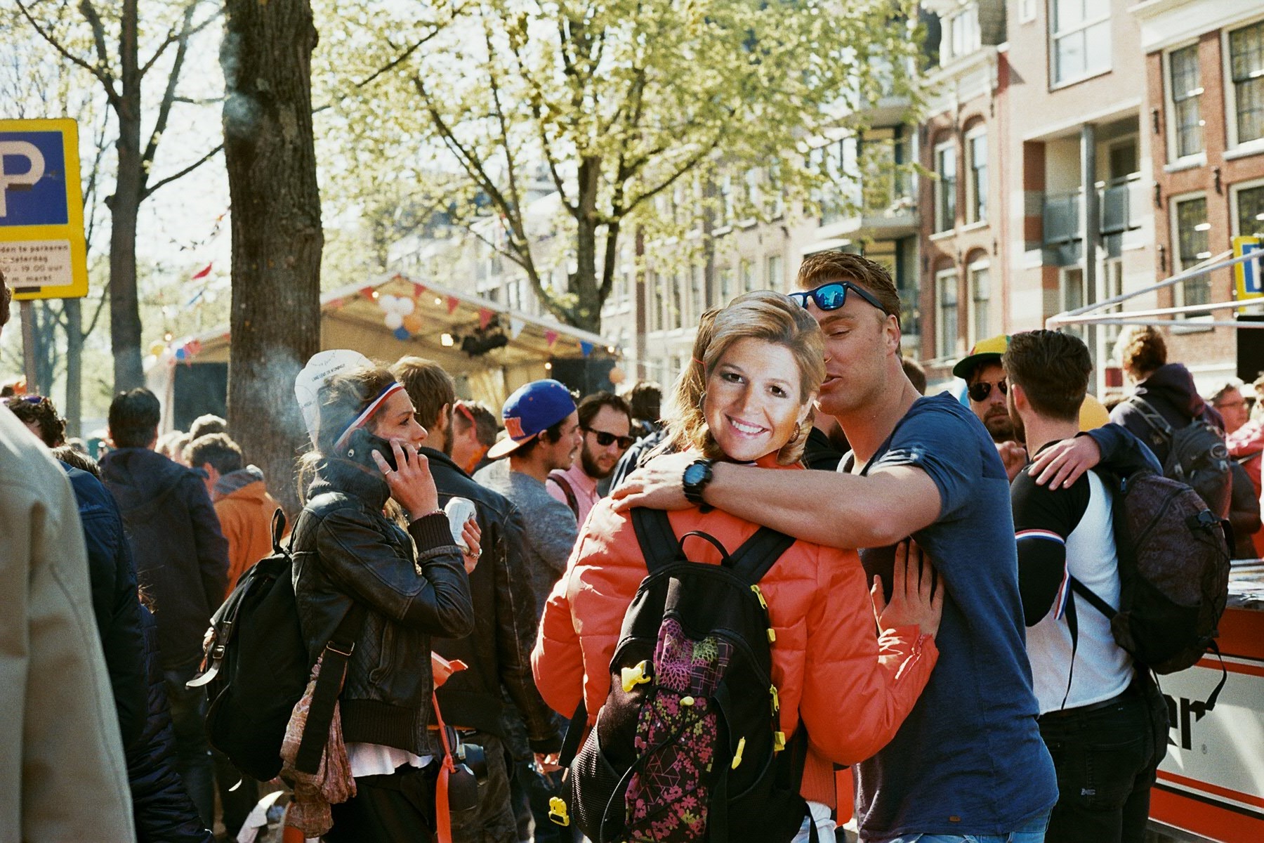 A couple making out on the street during a King's Day party