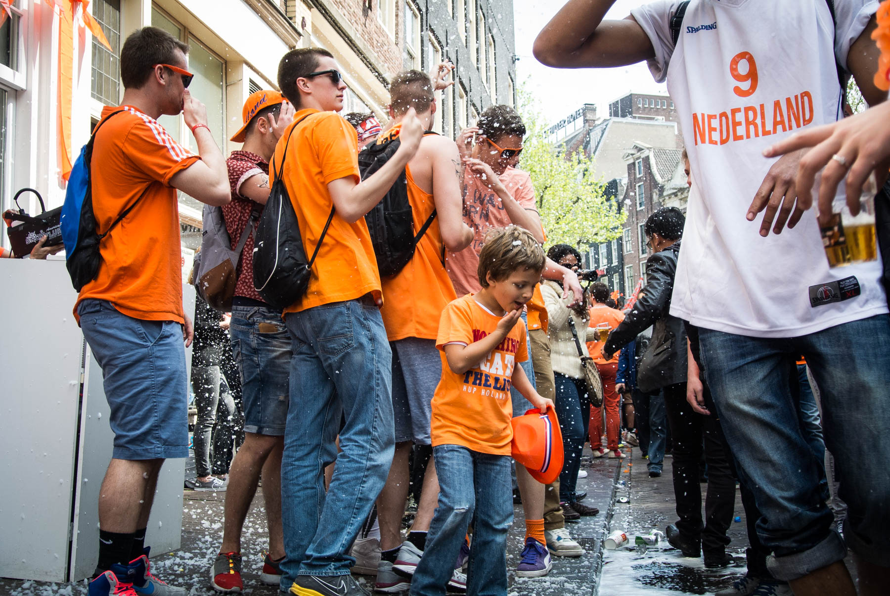 People partying on the street in orange clothes during King's Day in Amsterdam