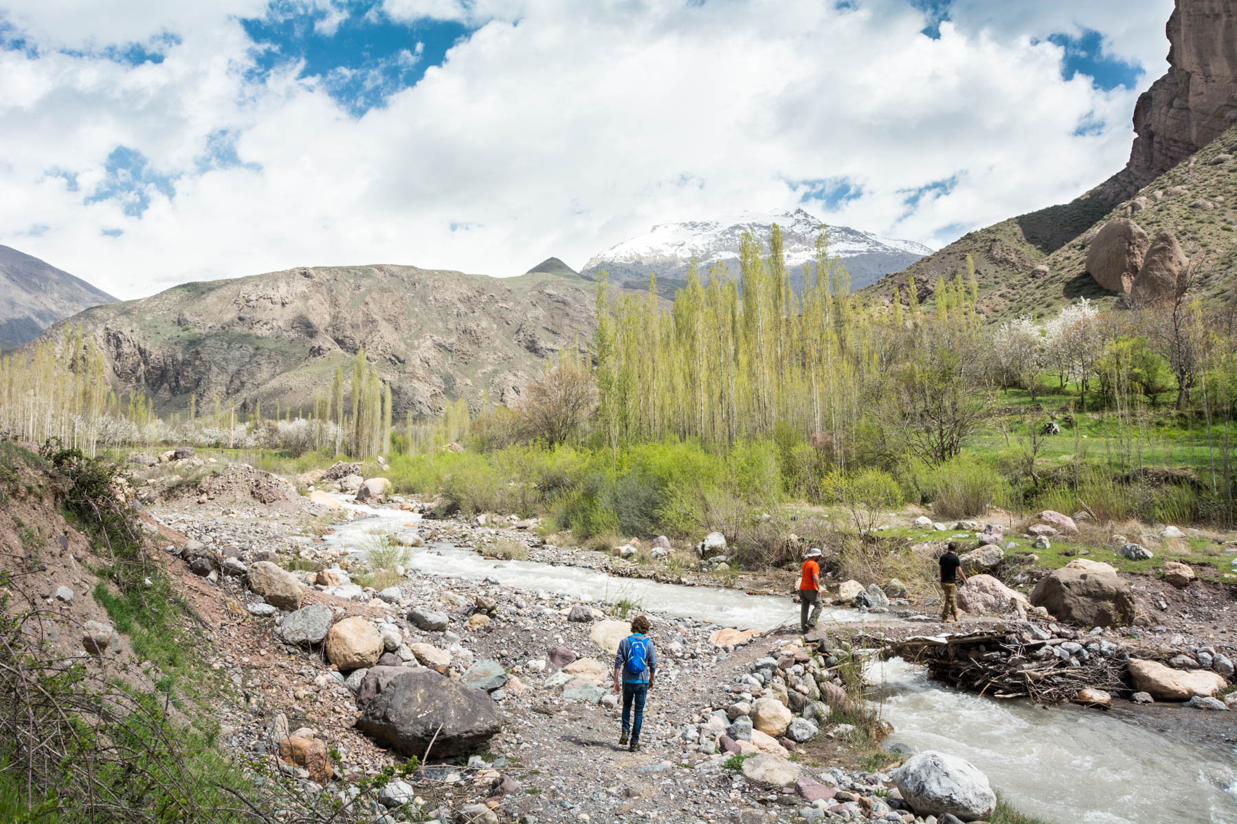 Two men crossing a stream to enter a gorge