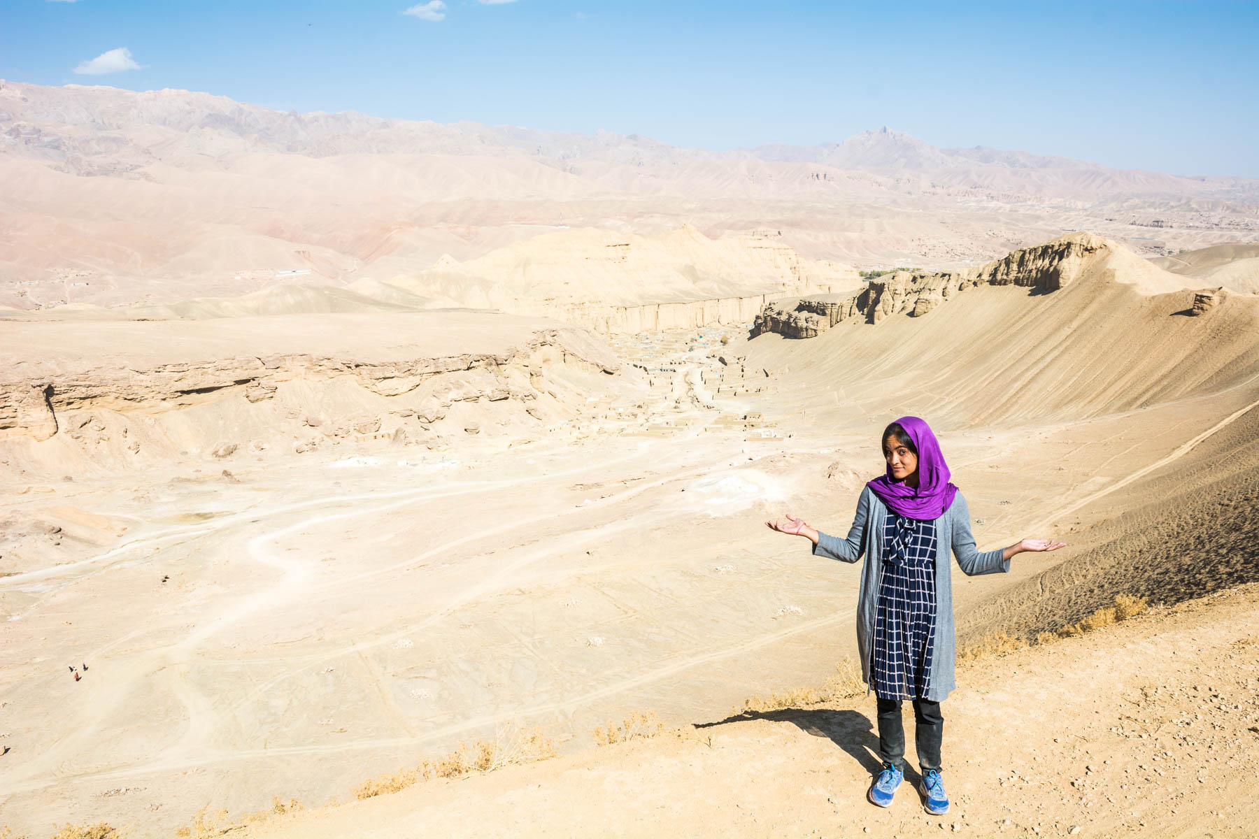 A female tourist staning in the desert in Afghanistan