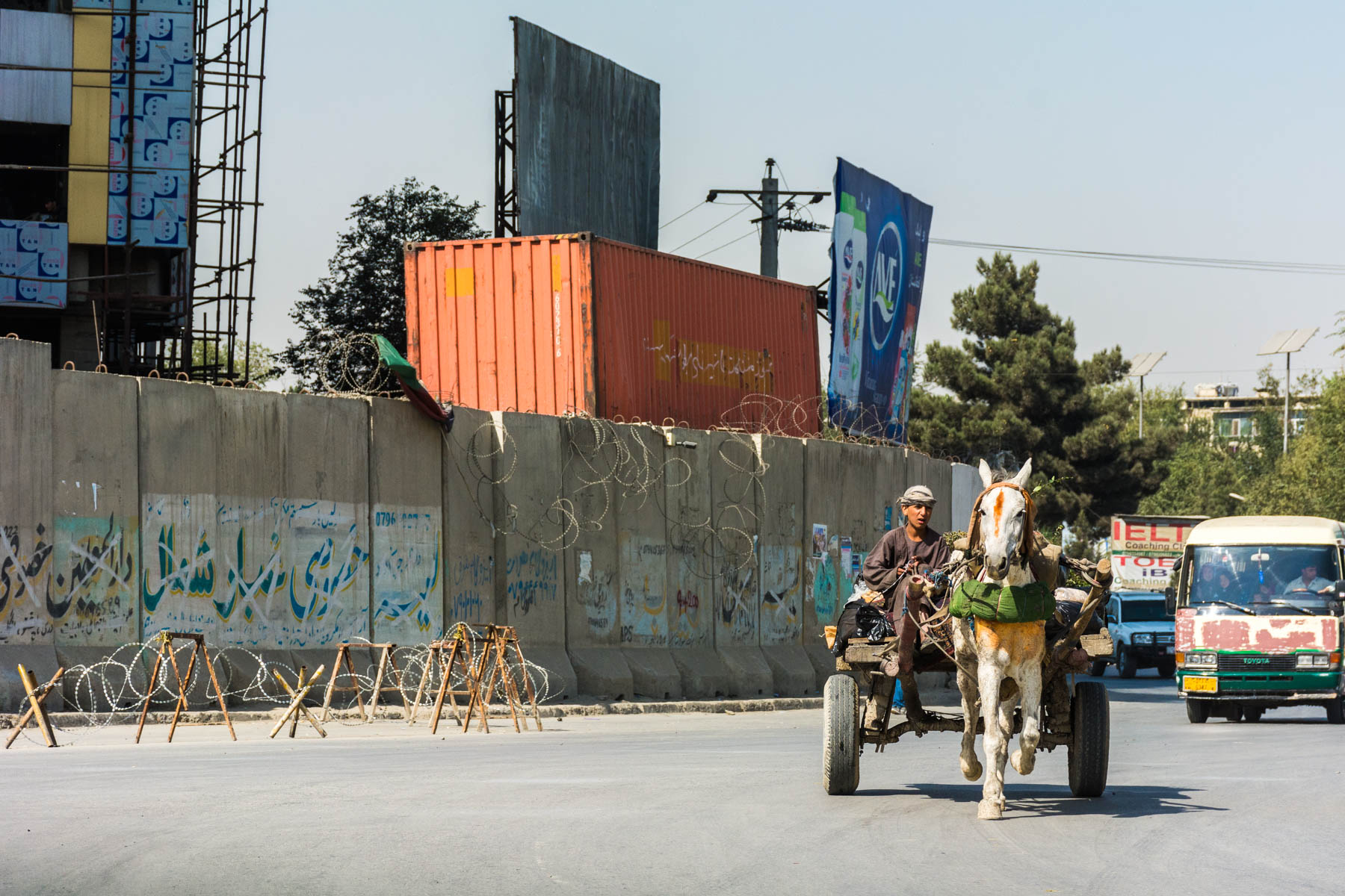 A donkey cart passing a blast wall in Kabul, Afghanistan