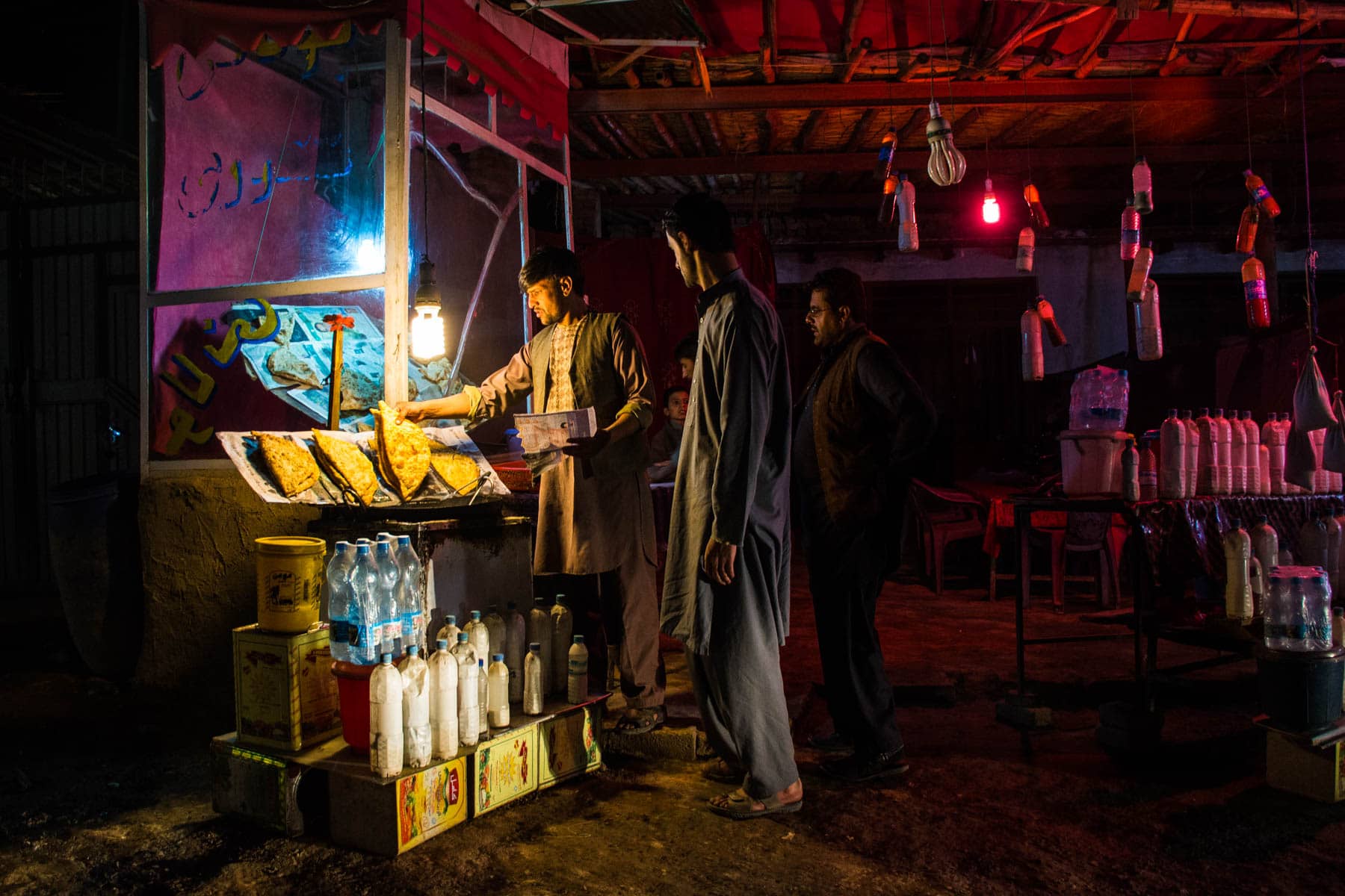 men getting food after dark in Kabul, Afghanistan
