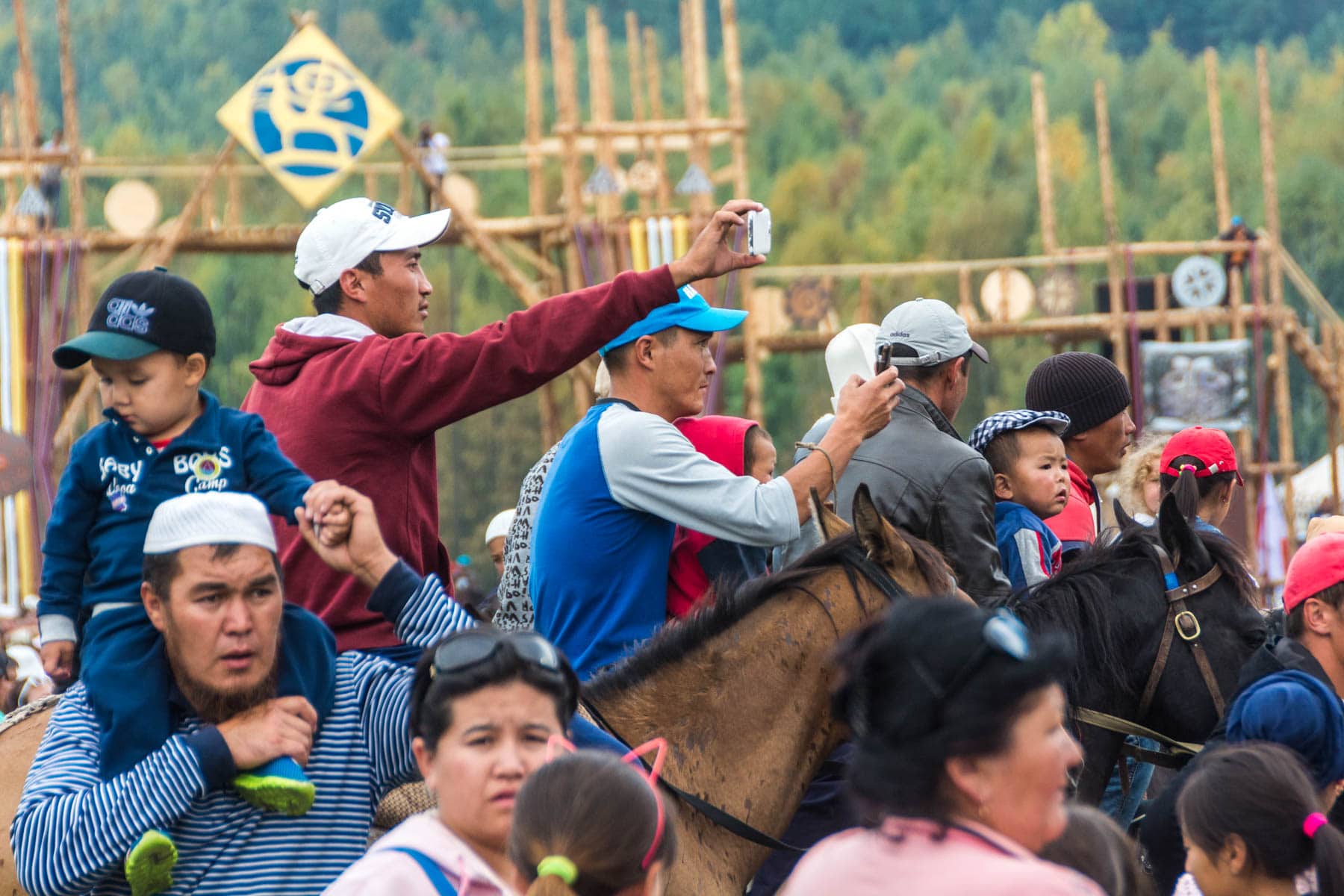 Men with phones on horseback at the World Nomad Games in Kyrgyzstan