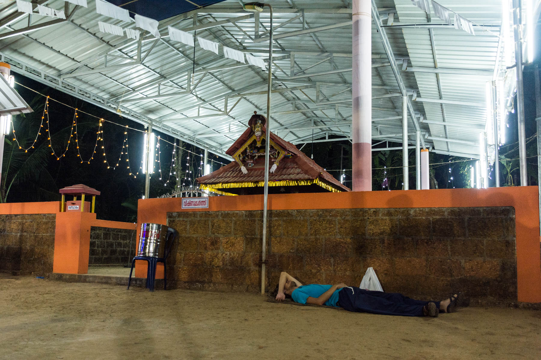 Boy sleeping on the floor at a temple after the performance