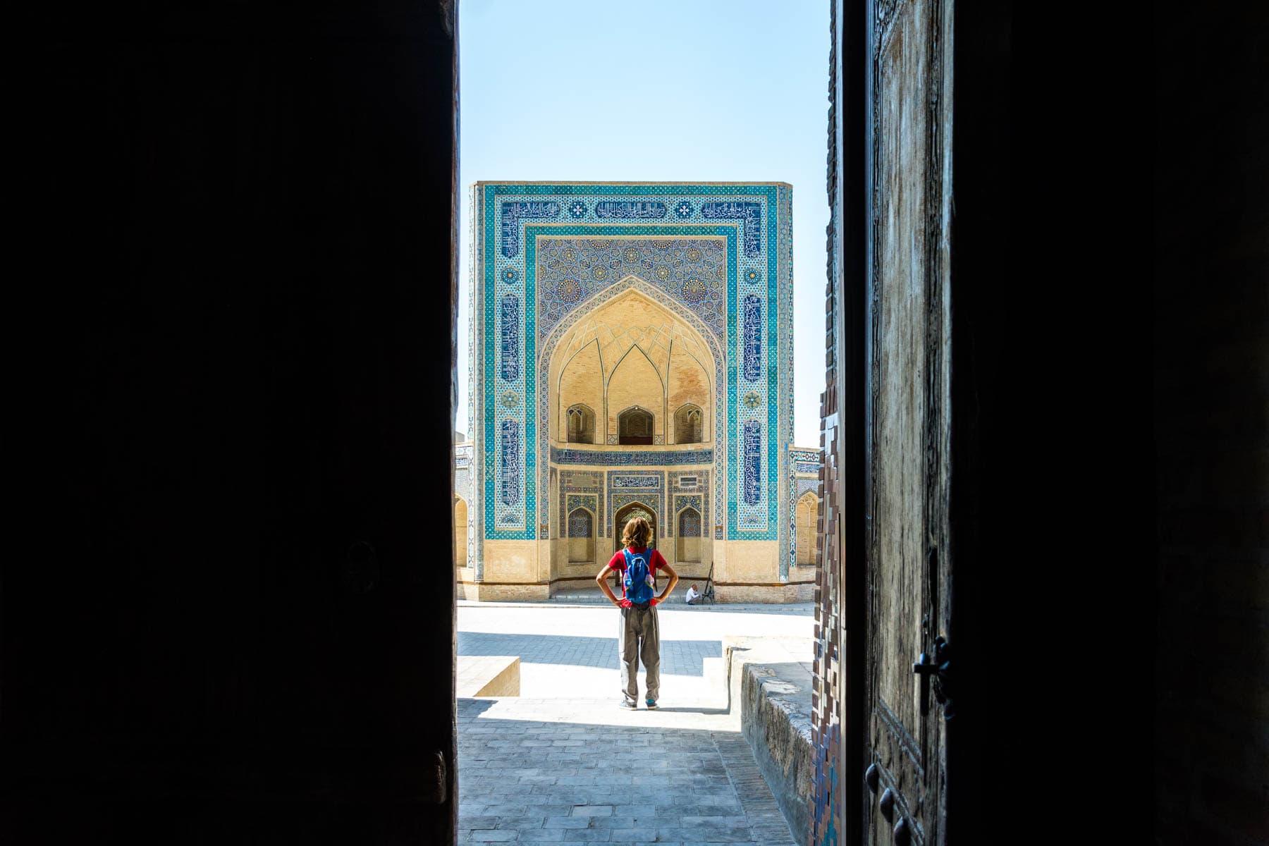 Two week Uzbekistan itinerary - Looking through doors to the Kaylan mosque in Bukhara, Uzbekistan - Lost With Purpose