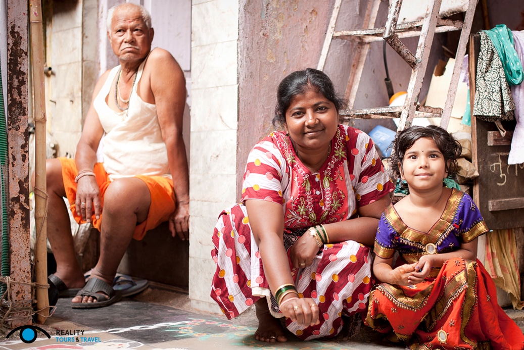 Is it weird to go on a slum tour in Mumbai, India? - Family in Dharavi slum - Photo by Reality Tours & Travel