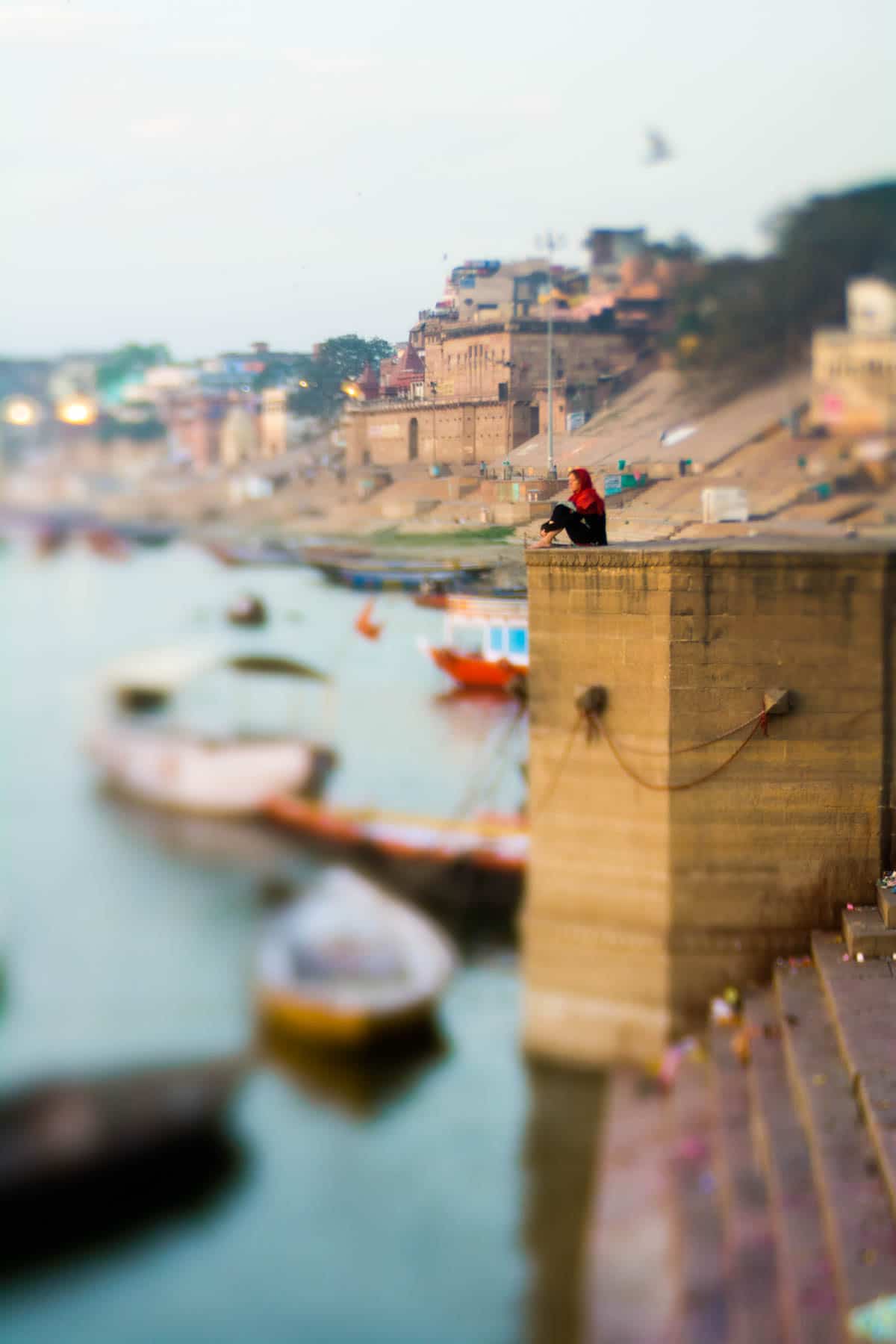 A tourist meditating on the ghats of Varanasi, India, shot with a Lensbaby Edge 50 optic.