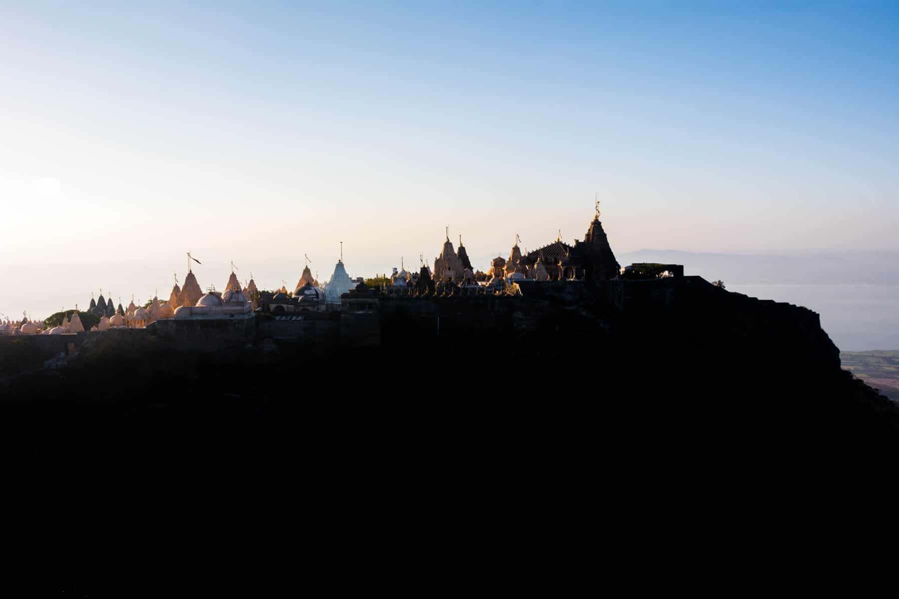 A Jain pilgrimage in Palitana, India - The holy mountain of Girnar with silhouettes of the temples near Palitana - Lost With Purpose