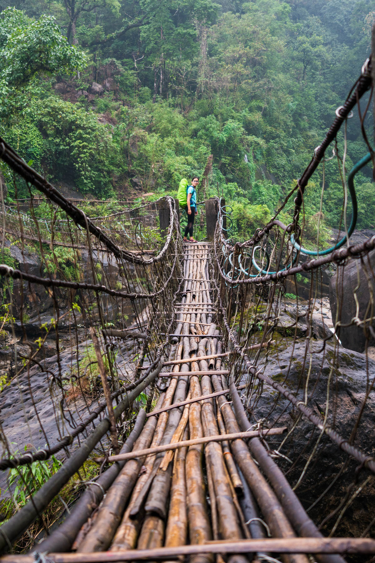 Alex standing at the end of a suspension bridge