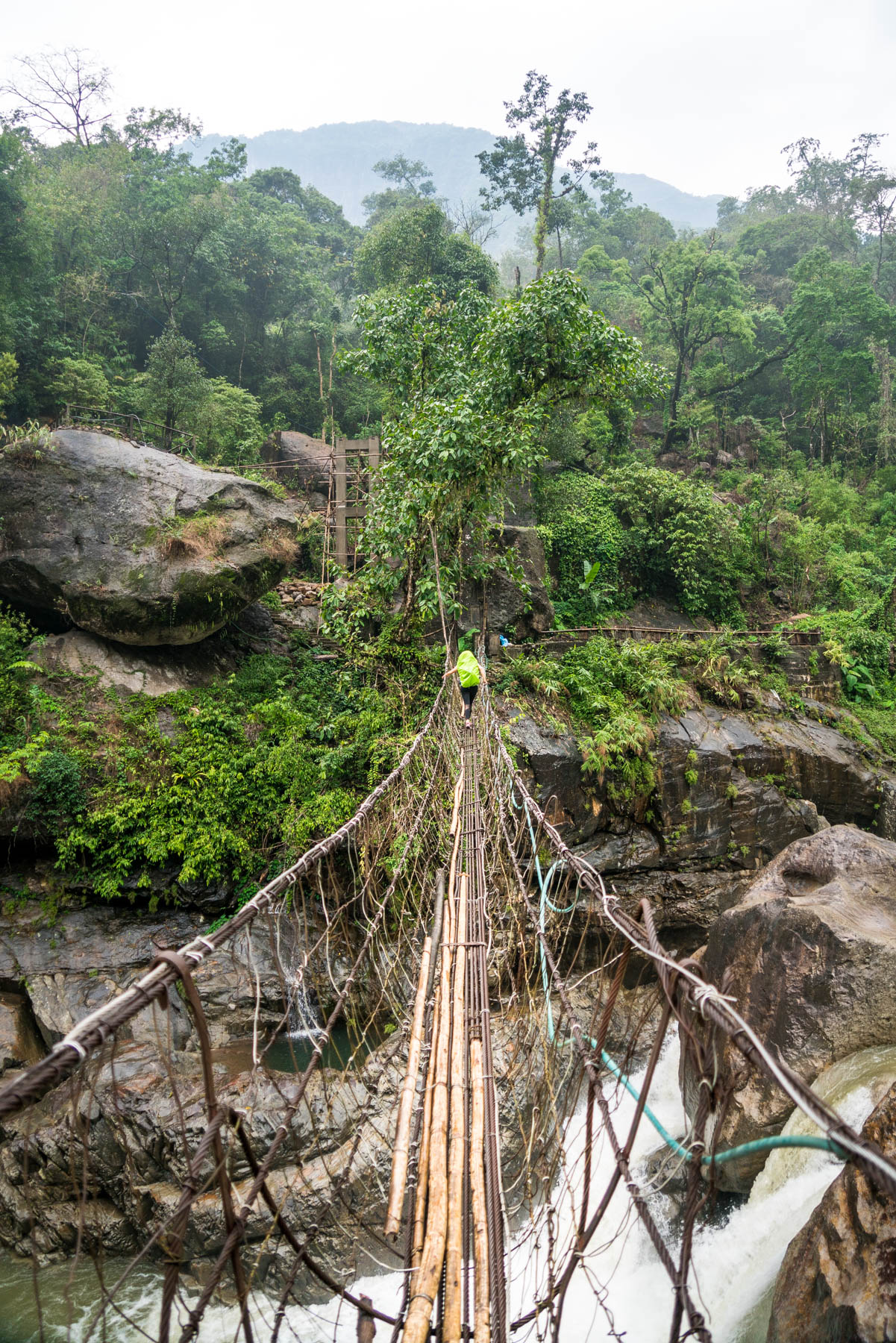 A wobbly suspension bridge over a river on the path