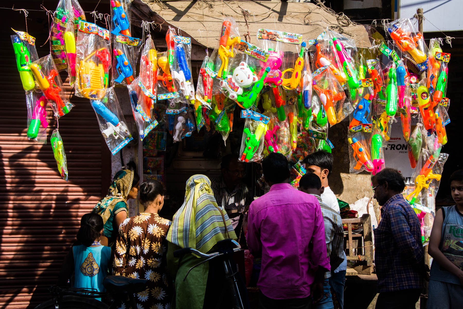 What you need know about playing Holi in Varanasi, India - Locals buying water guns in preparation for Holi in Varanasi - Lost With Purpose