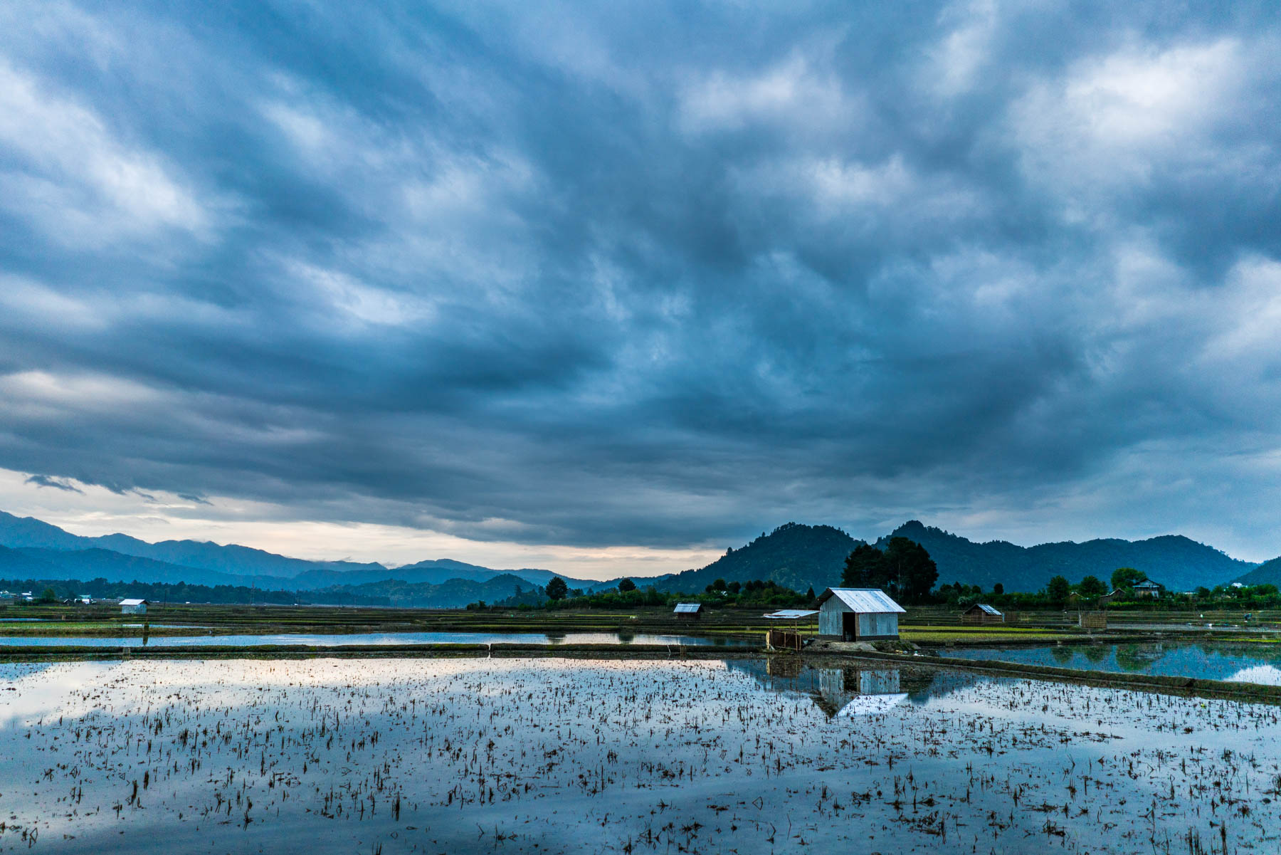 Backpacking in Arunachal Pradesh travel guide - Epic clouds reflecting over rice paddy waters in Ziro Valley - Lost With Purpose