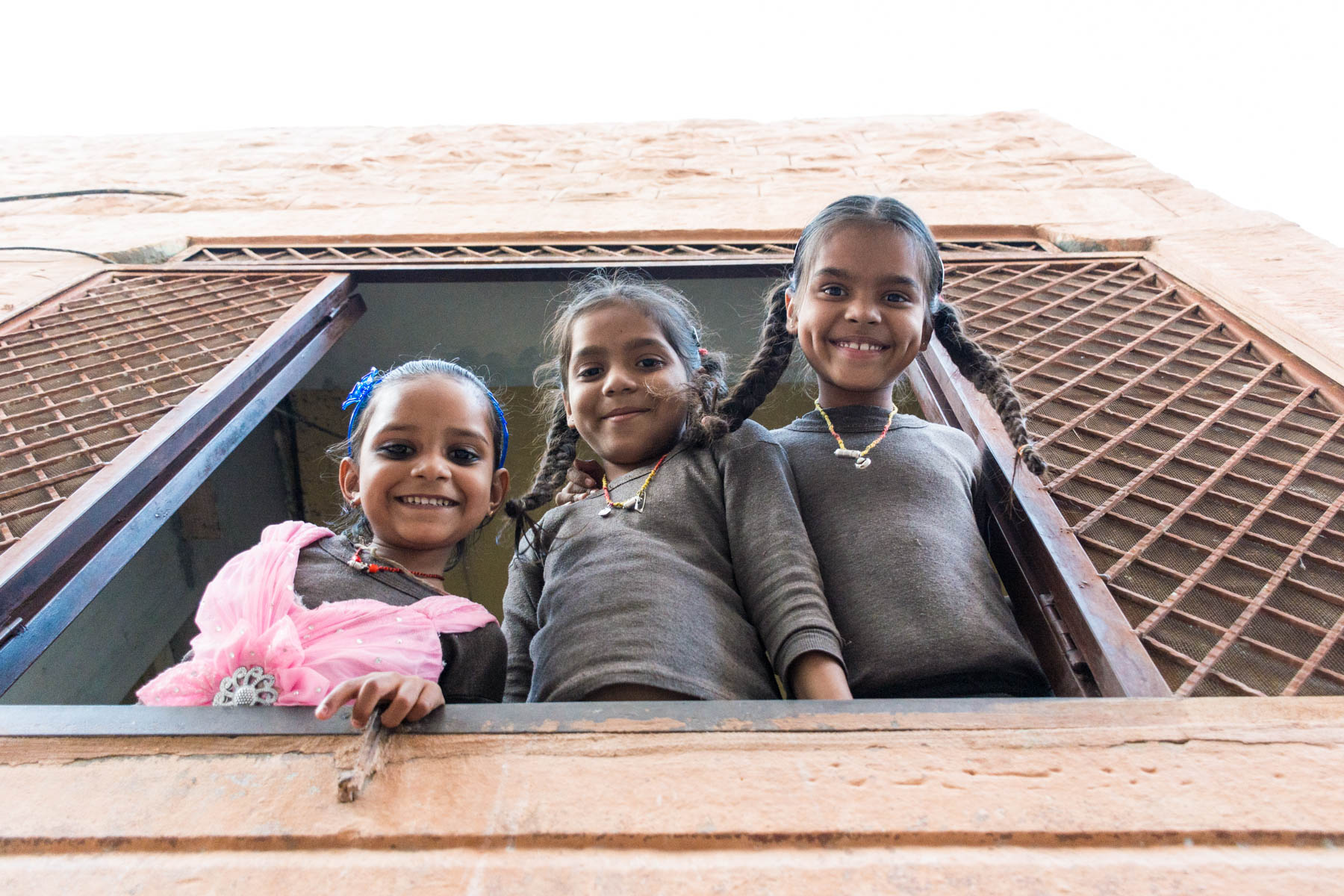 Girls hanging out the window in Jodhpur