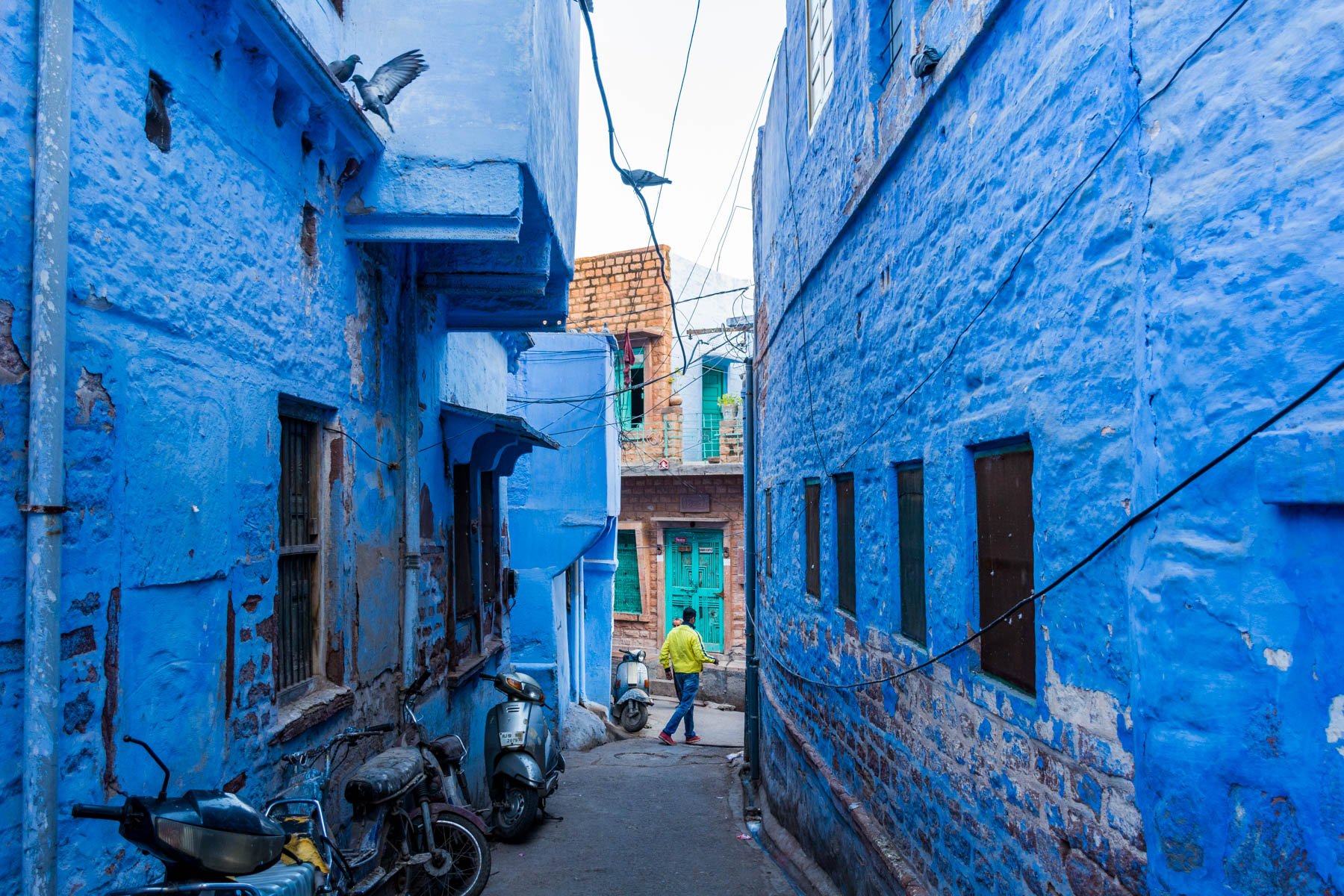 A man walking through a blue neighborhood in Jodhpur