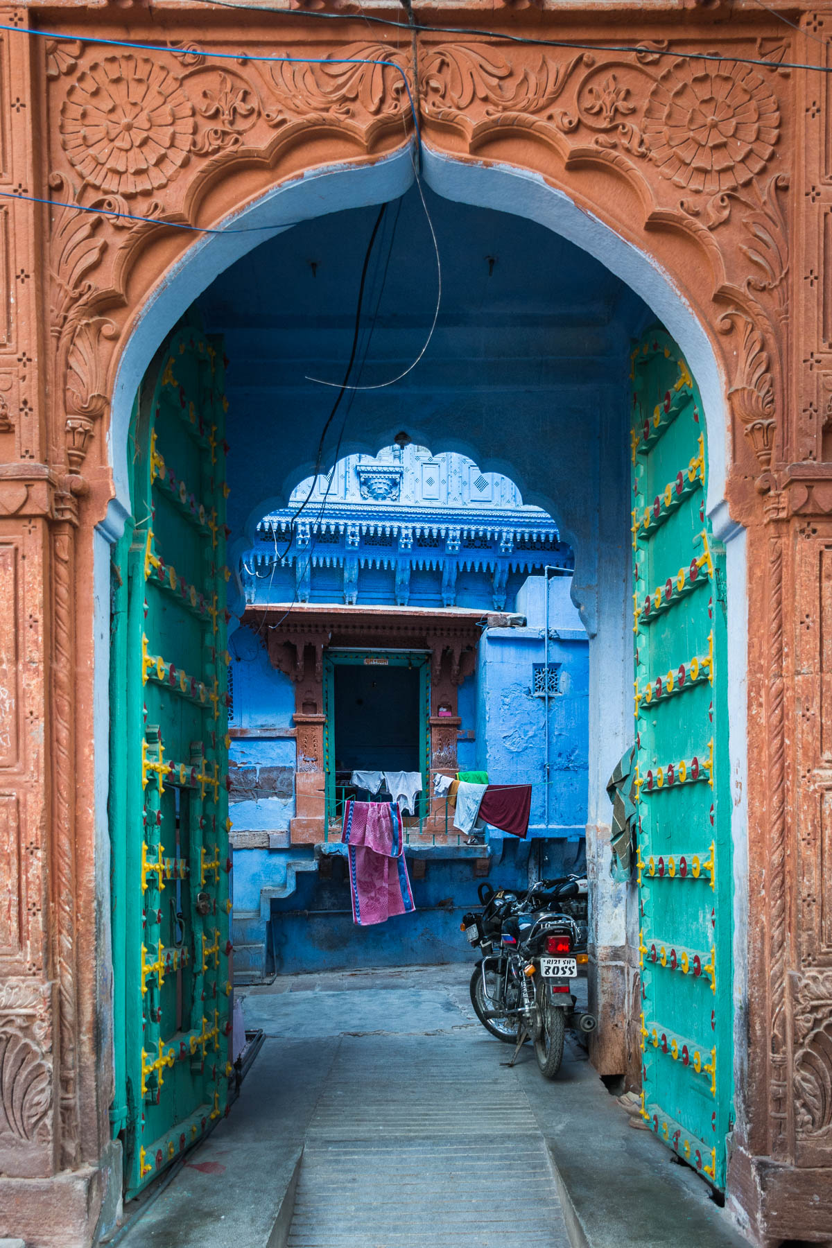 A blue house and beautifully detailed archway and door in Jodhpur, Rajasthan, India