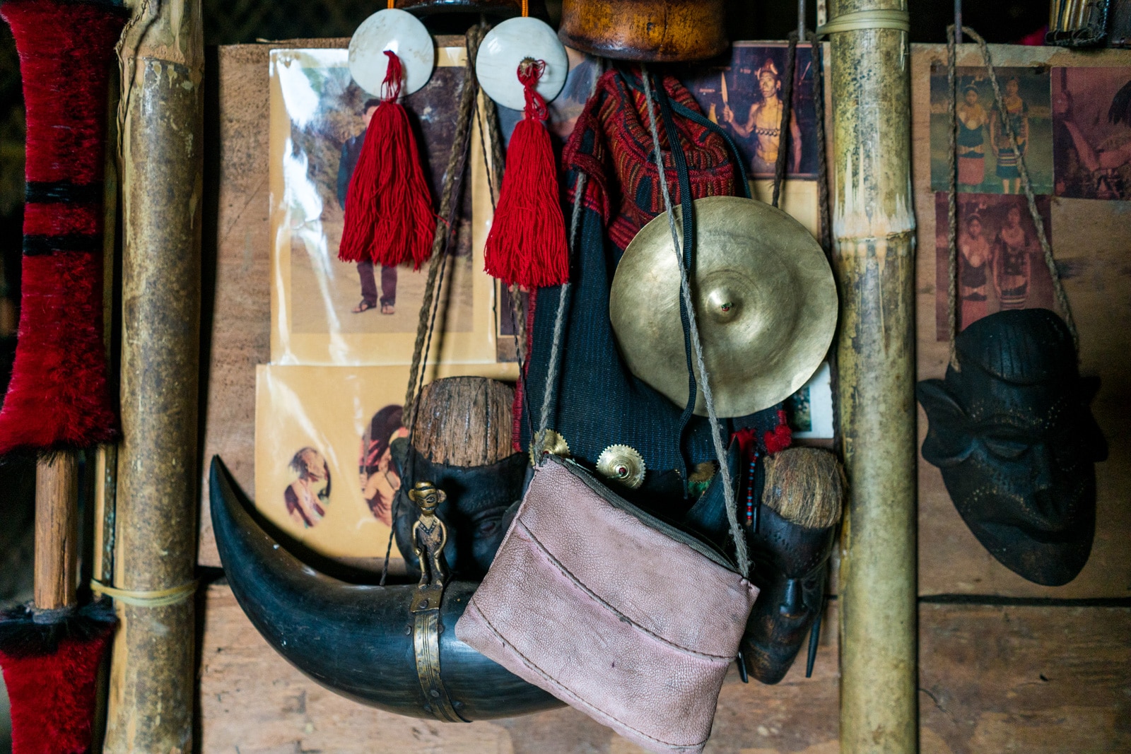 Spears, red tassels, and photos on the bamboo hut wall