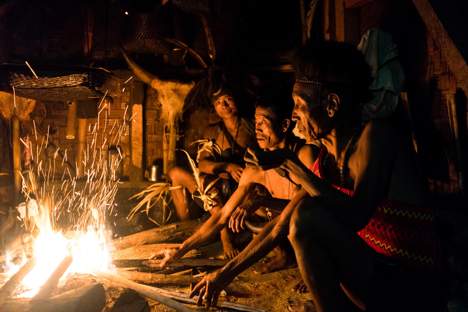 Snapshots of traditional tribal culture in Longwa village, Nagaland, Northeast India - Longwa men sitting around a fire - Lost With Purpose Travel Blog