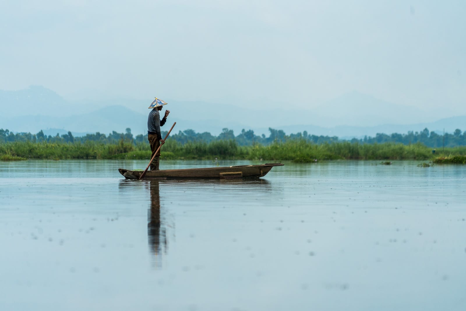 Why you need to visit Loktak Lake, Manipur, Northeast India - Fisherman standing in boat - Lost With Purpose