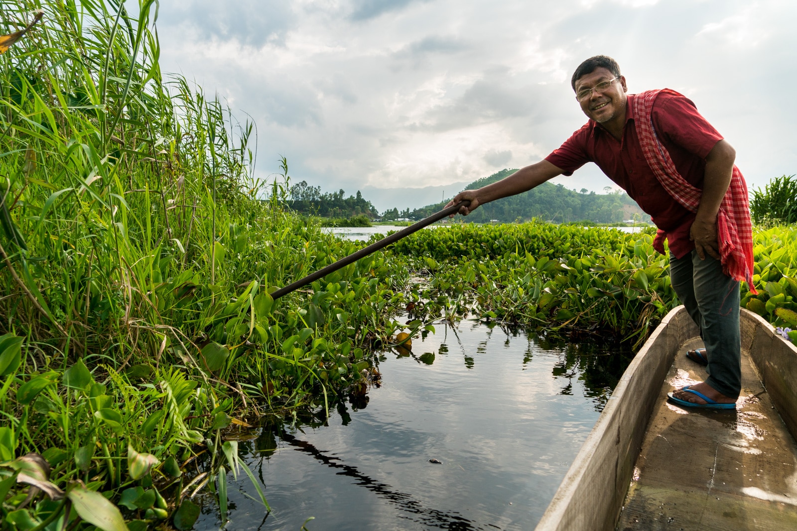 Why you need to visit Loktak Lake, Manipur, Northeast India - Clearing a path through the phumdi on a boat ride in the lake - Lost With Purpose