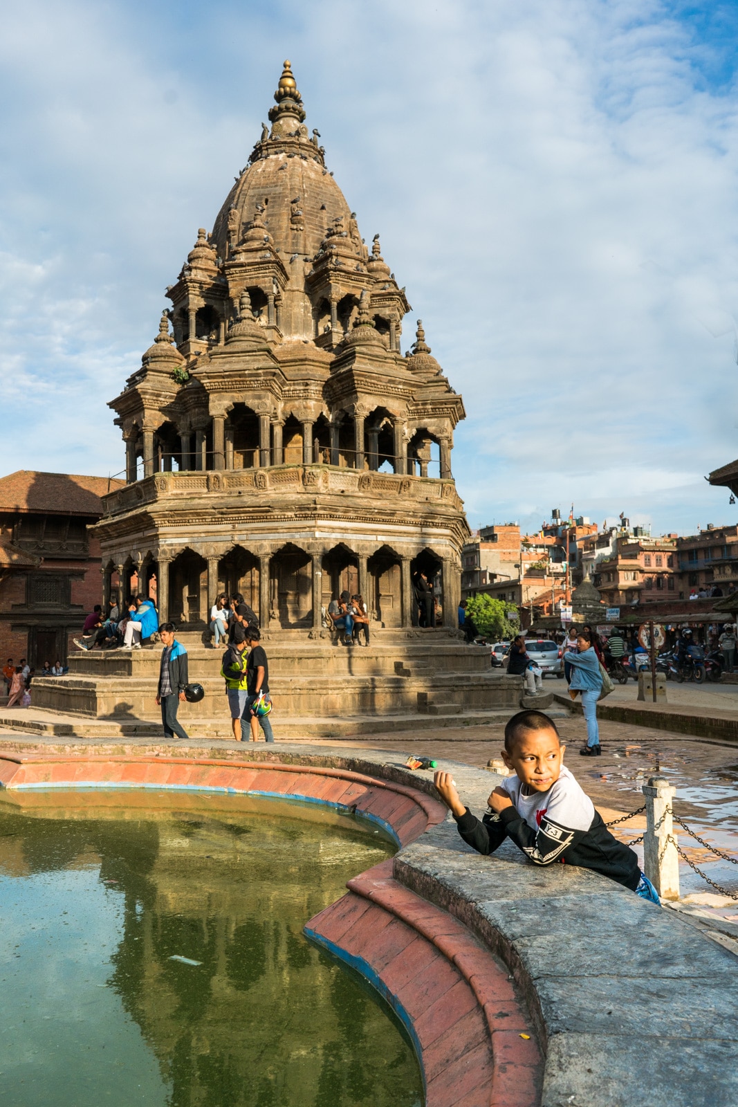 Devious young boy having an ice cream snack in the historic Durbar Square in Patan, Nepal.