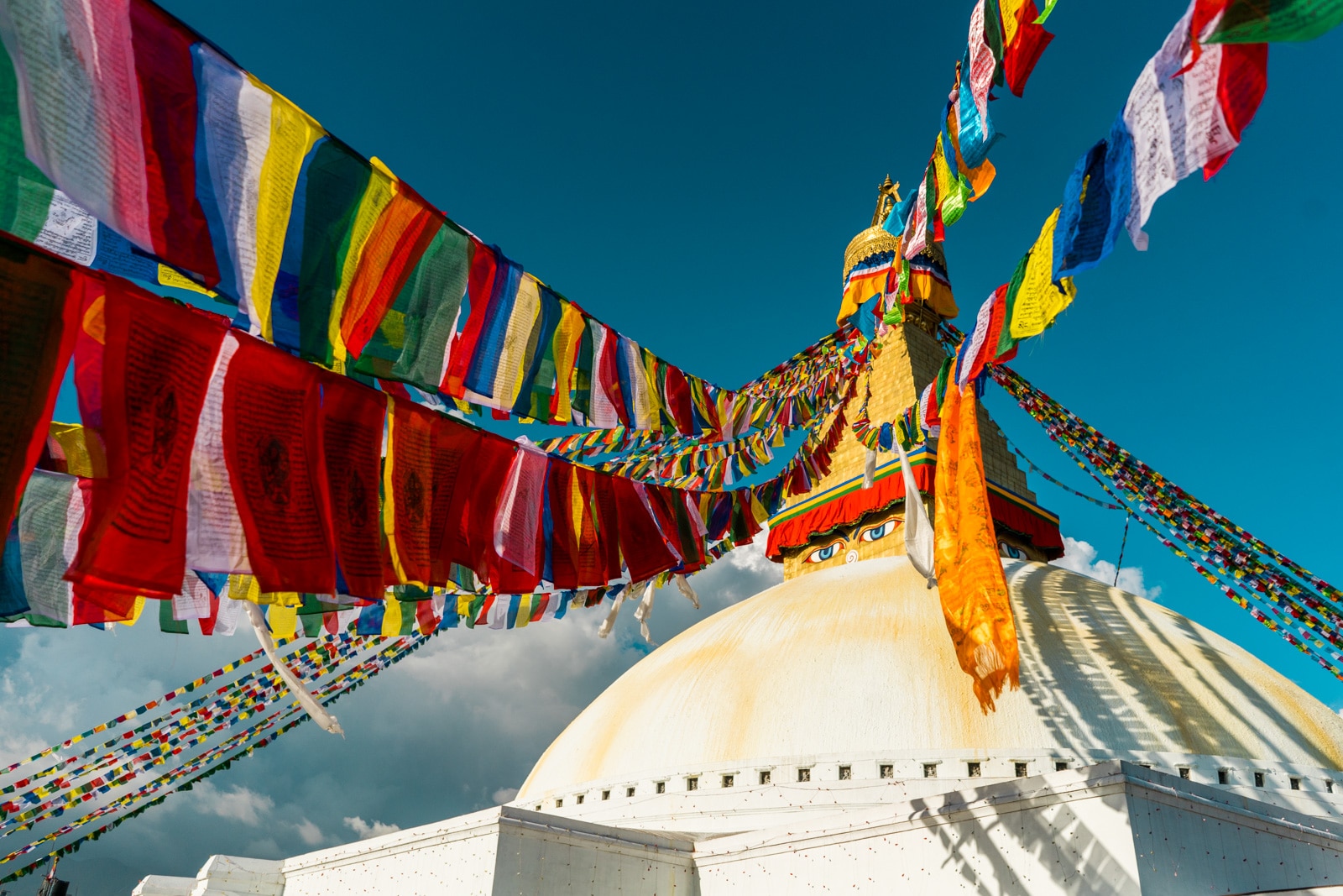 Traveling during monsoon in Nepal - Boudhanath stupa and prayer flags in the sun - Lost With Purpose travel blog