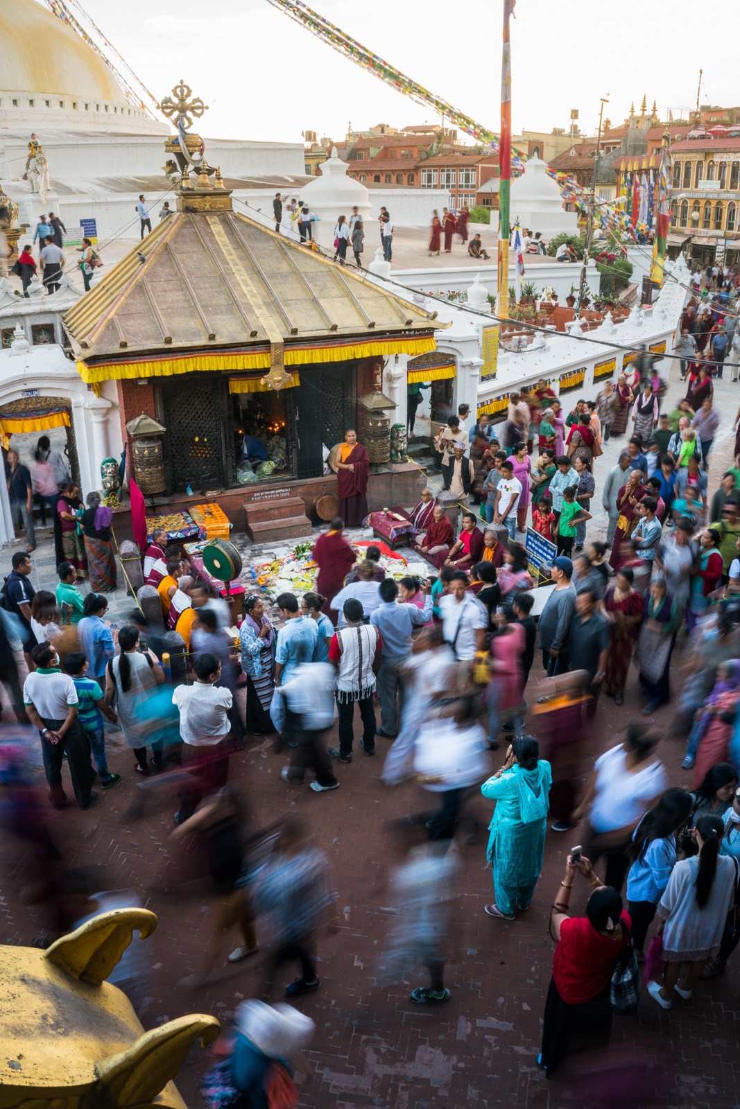 Rushing crowds of pilgrims and travelers visiting the famous UNESCO World Heritage site of Boudhanath stupa in Kathmandu, Nepal.