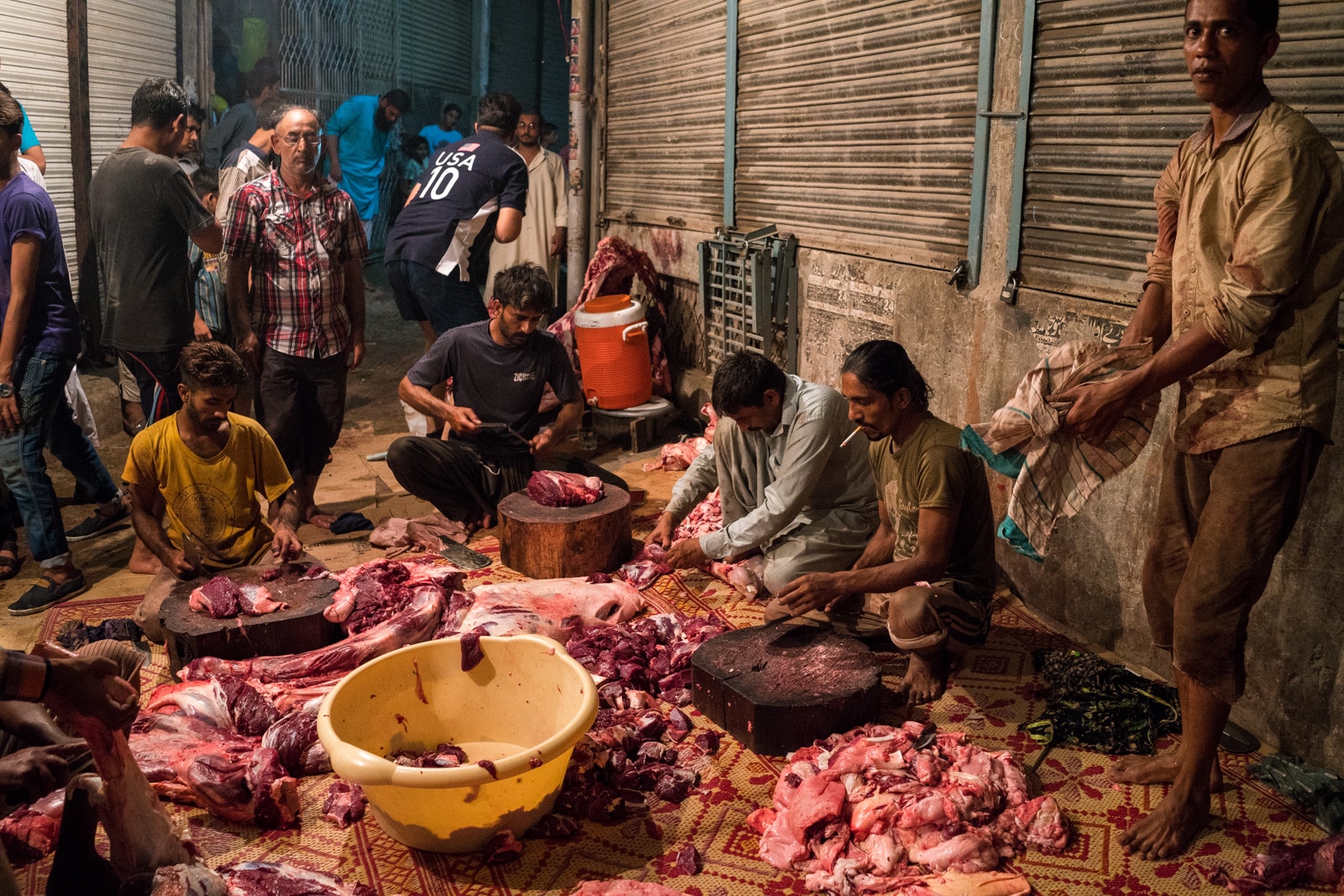 Celebrating Eid al-Adha in Lahore, Pakistan - Men chopping camel meat on the street - Lost With Purpose travel blog