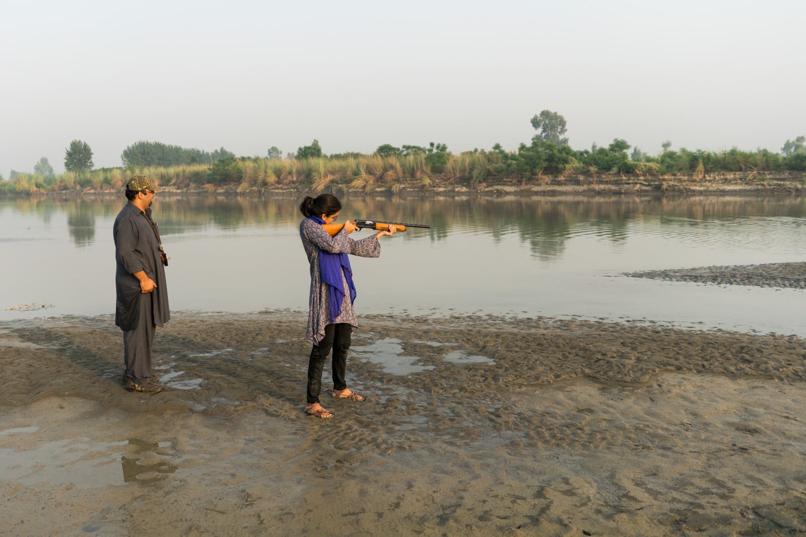 The most hospitable people in Pakistan - Hamza and Alex using a rifle on the Kabul river - Lost With Purpose travel blog