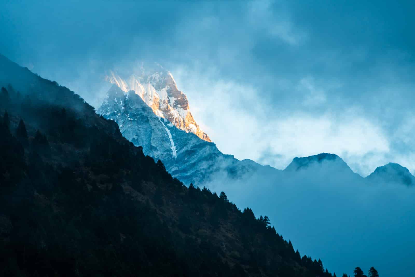 Guide to the Gasa - Laya trek in Bhutan - Mountain peeking through the clouds at sunrise - Lost With Purpose travel blog