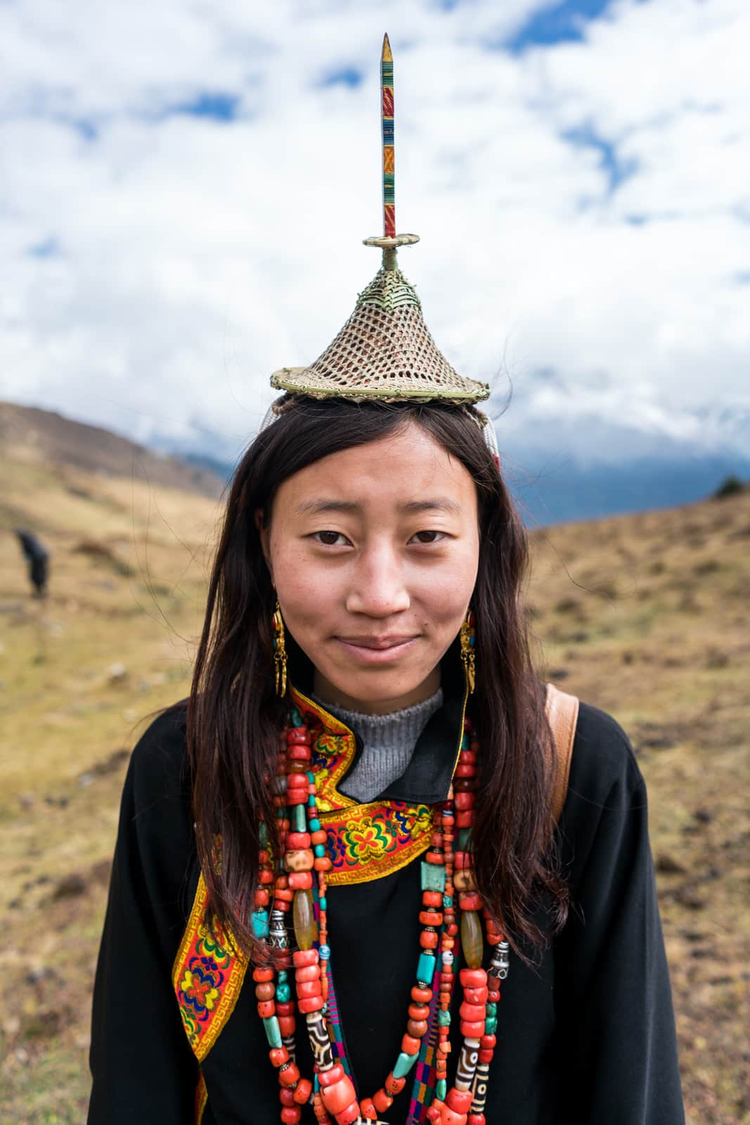 Portrait of a Layap girl in traditional headdress, dress, and beads at the 2017 Royal Highlander Festival in Laya, Bhutan. The perfect off the beaten track adventure in Bhutan!