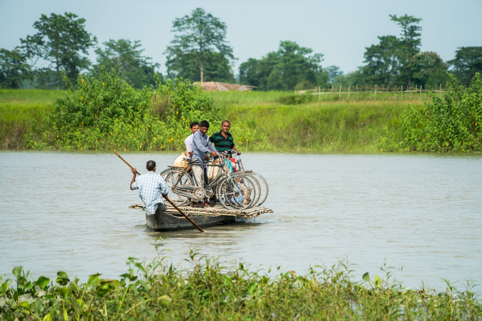 Men standing on a small ferry for cyclists in Majuli river island in Assam, India