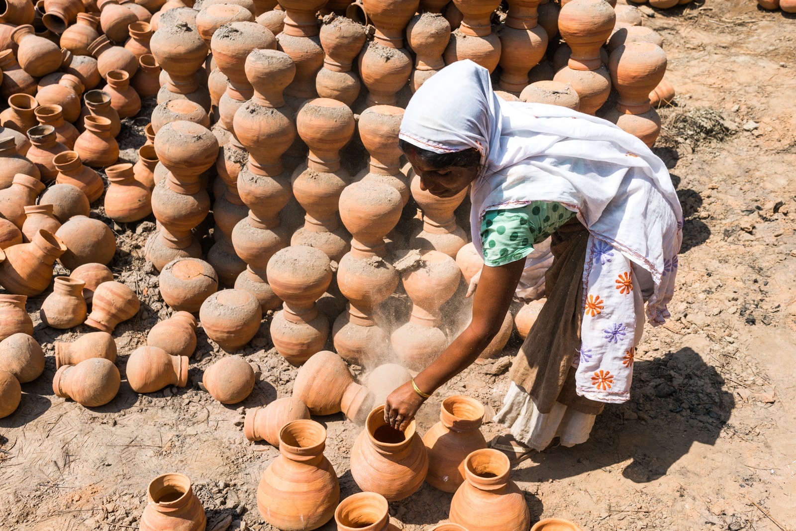 A Kumar woman making clay pots from mud