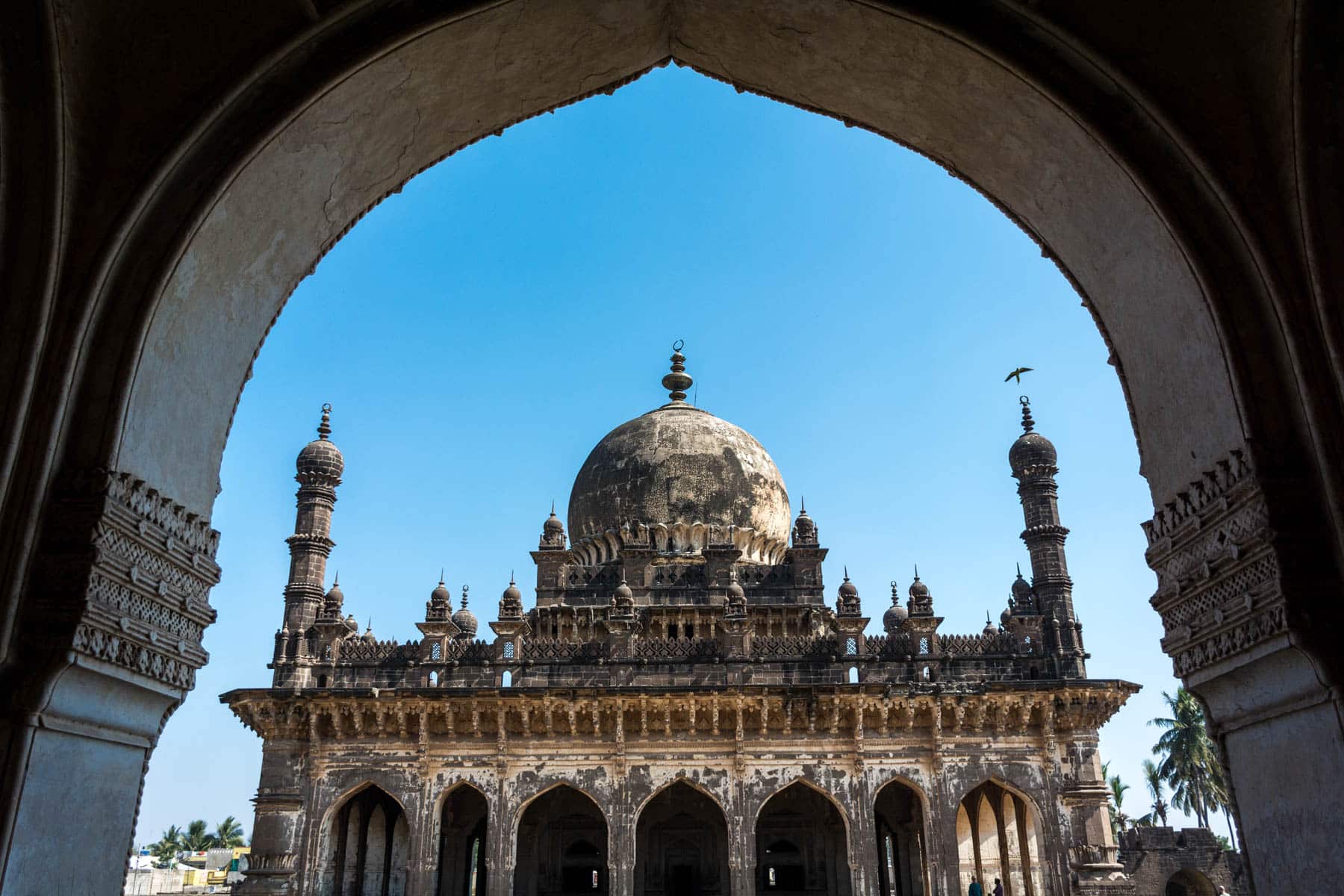 Best destinations off the beaten track in India - Ibrahim Rauza mausoleum through an archway in Bijapur, Karnataka - Lost With Purpose travel blog