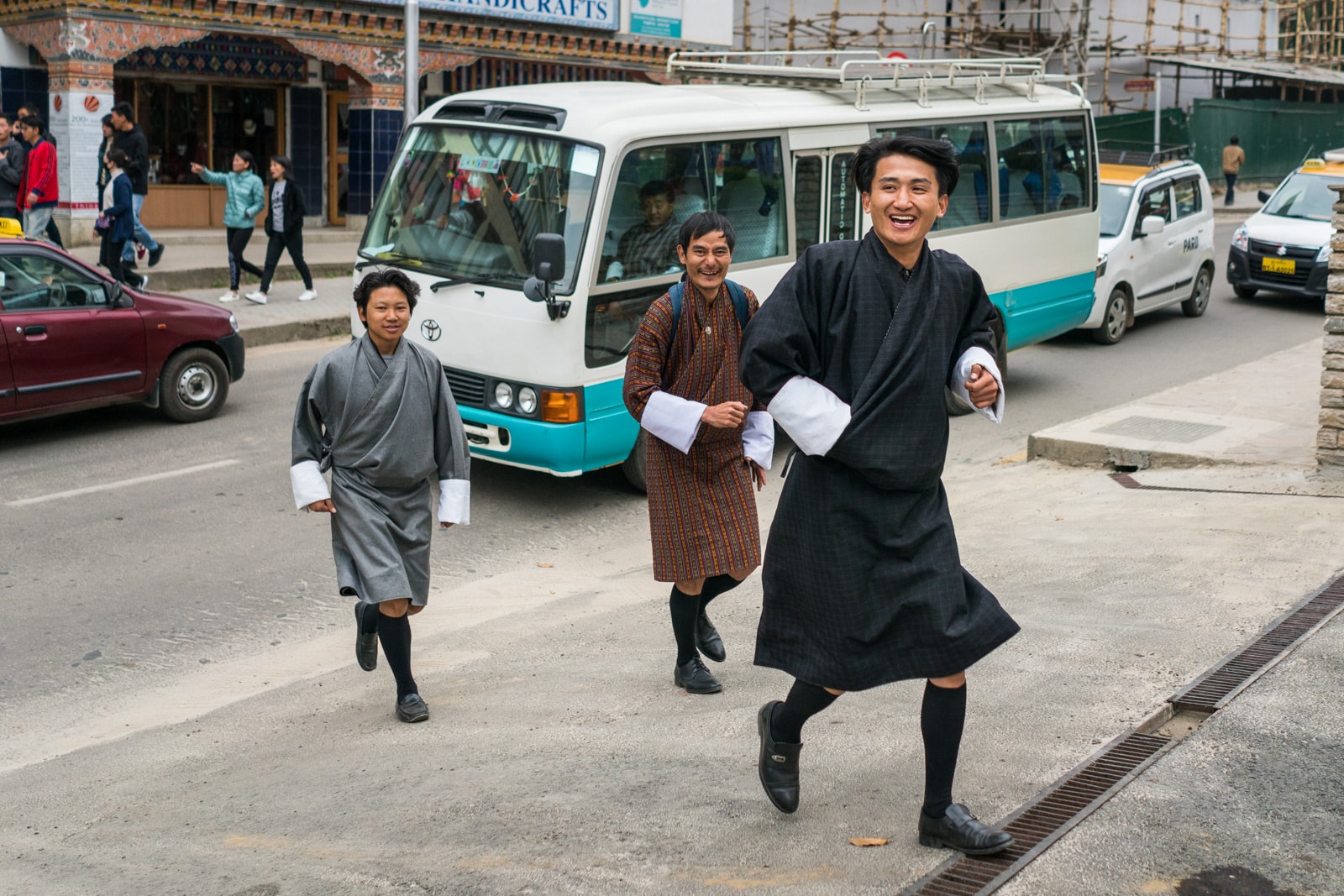 What it's like to go on a guided tour in Bhutan - Three tour guides walking on the streets of Thimphu - Lost With Purpose travel blog