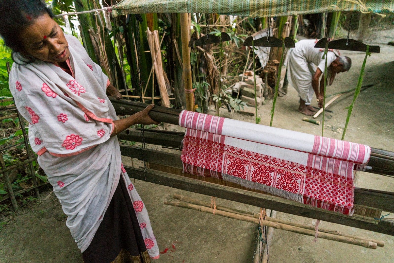 Luxury river cruise in India with Assam Bengal Navigation - Assamese woman showing off gamosa scarf weaving on a loom - Lost With Purpose travel blog