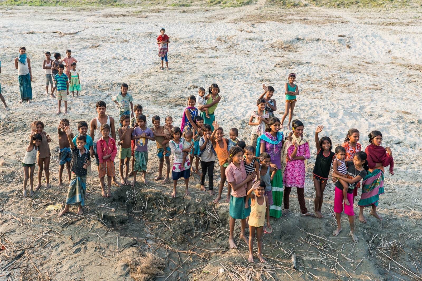 River cruising on the Brahmaputra river in Assam - Children waving goodbye in Khirakanta village - Lost With Purpose travel blog