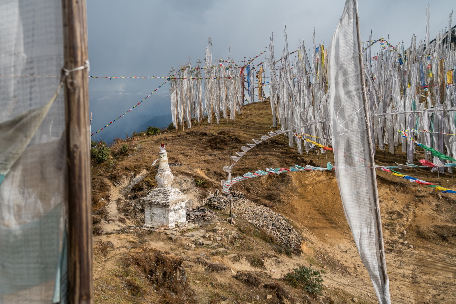White prayer flags and a small stupa on Chele La mountain pass