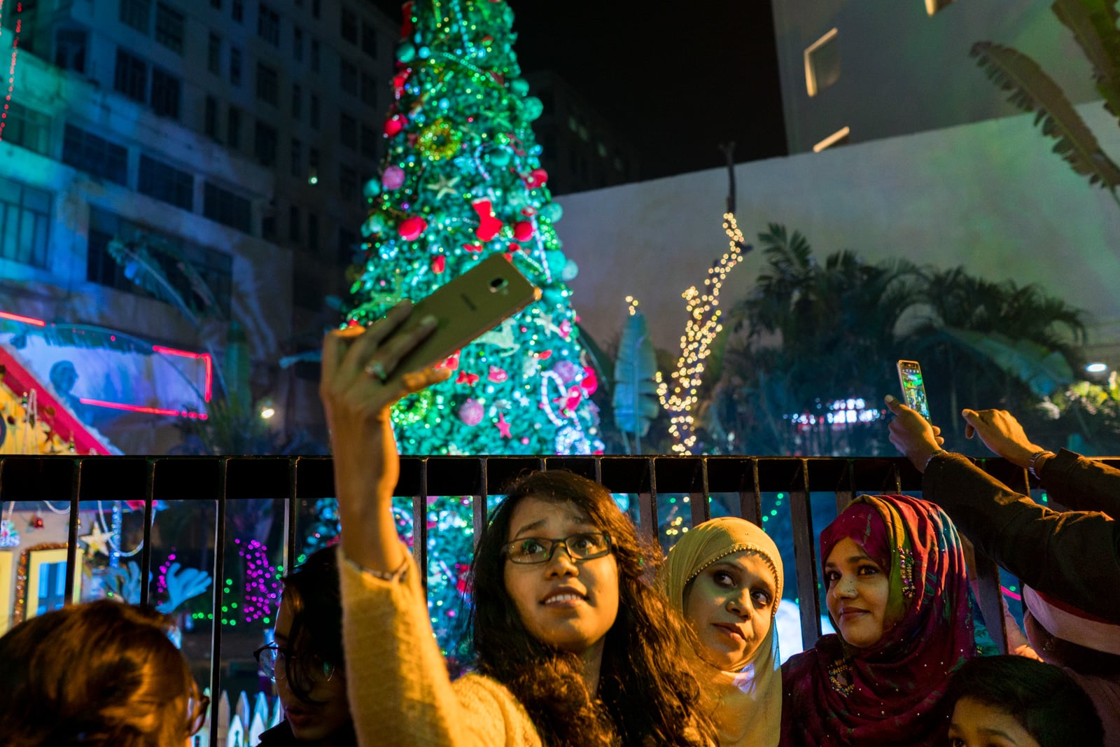 Christmas in Kolkata, India - Girls in hijab taking selfies in front of a Christmas tree on Park Street - Lost With Purpose travel blog