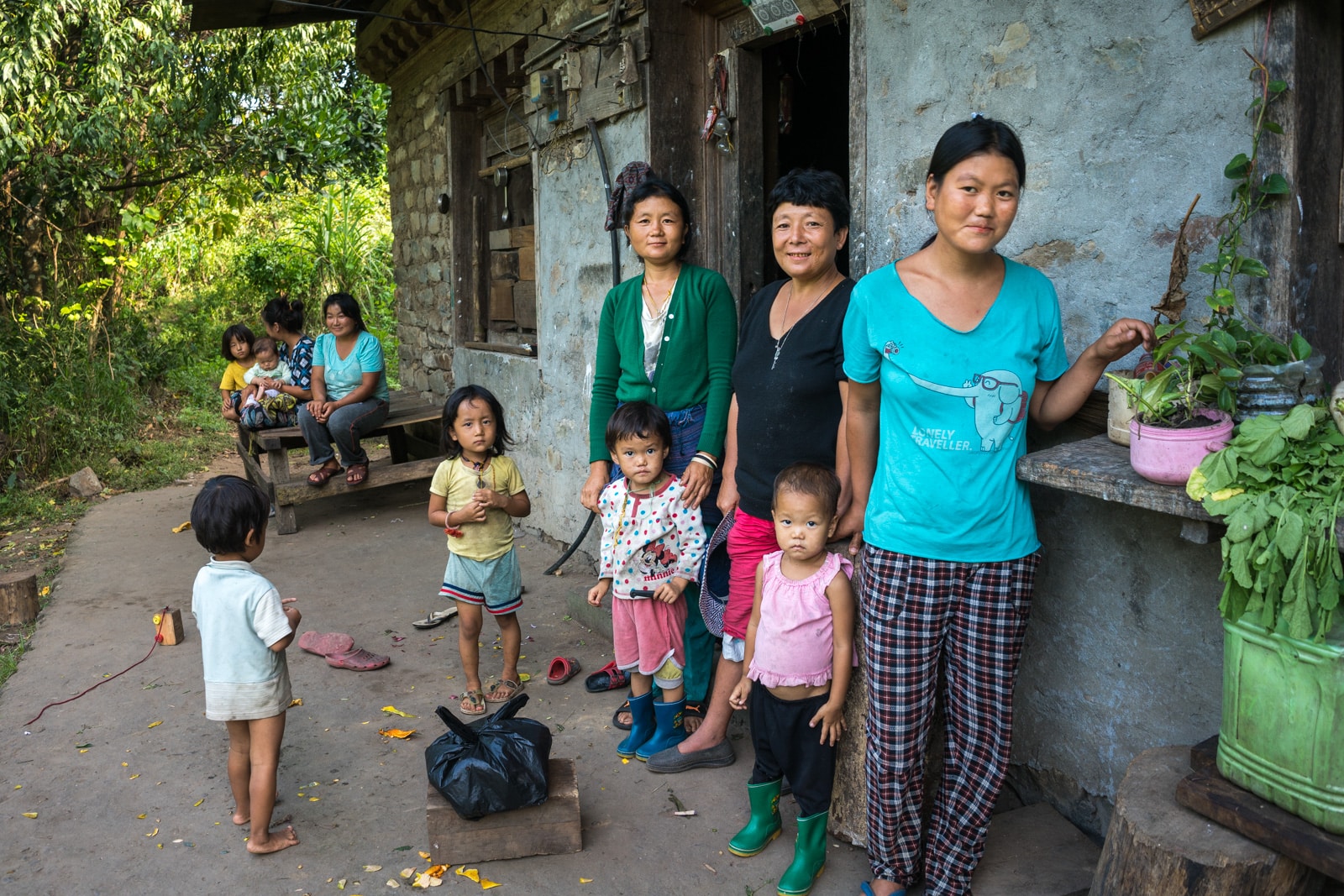 Traveling off the beaten track in Bhutan - A family standing outside a house in Birtii - Lost With Purpose travel blog