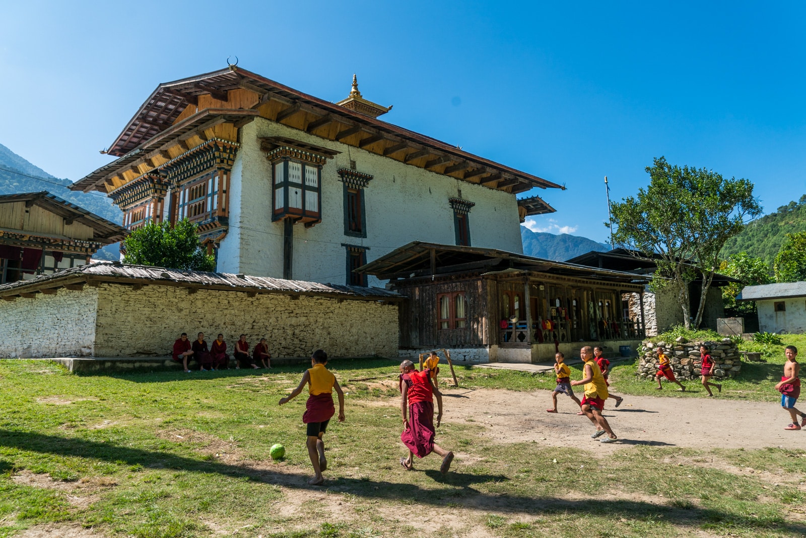 Stunning photos of Bhutan - Young monks playing football outside Inndocholing dzong - Lost With Purpose travel blog