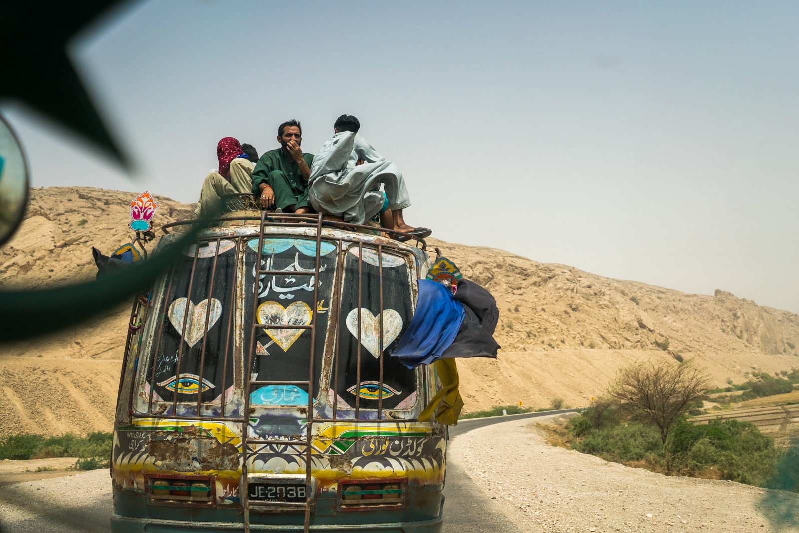 The Urs of Lal Shahbaz Qalandar in Sehwan, Pakistan - Men riding on top of a bus - Lost With Purpose travel blog