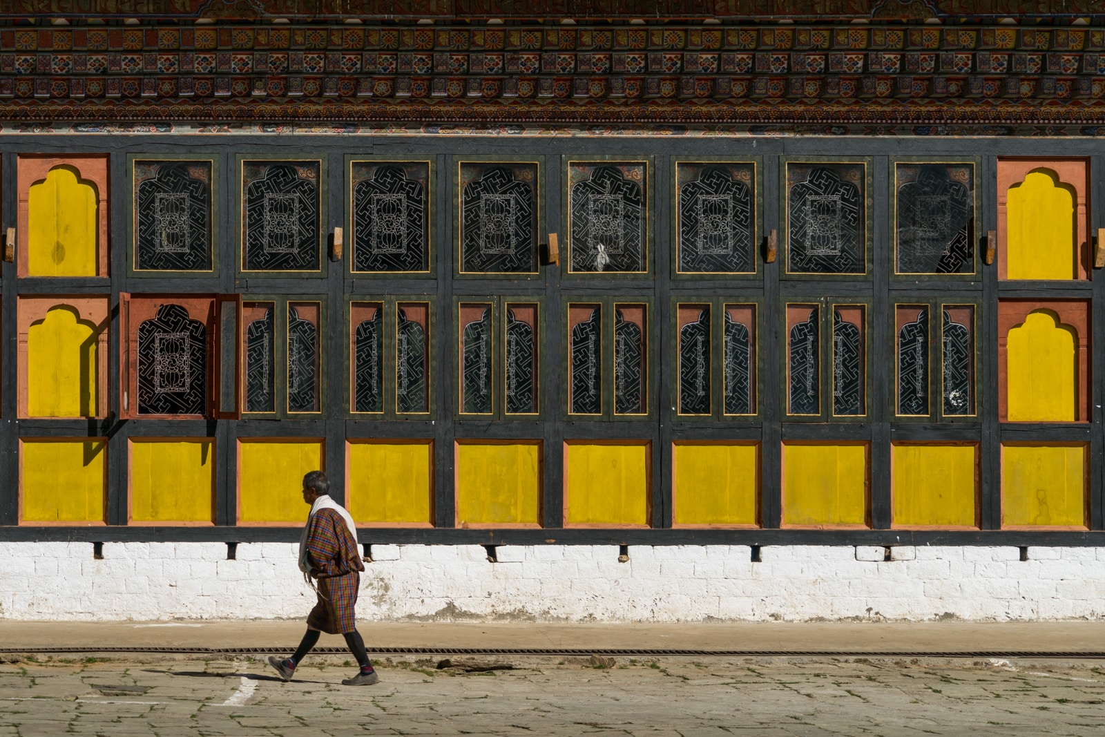 Stunning photos of Bhutan - Man walking in traditional gho in Gangtey Monastery - Lost With Purpose travel blog