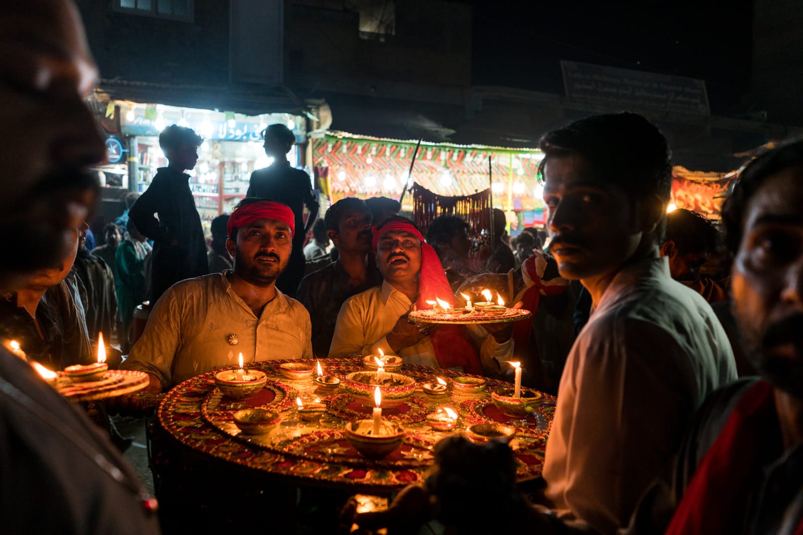 The Urs of Lal Shahbaz Qalandar in Sehwan, Pakistan - Men with candles on the streets at night - Lost With Purpose travel blog