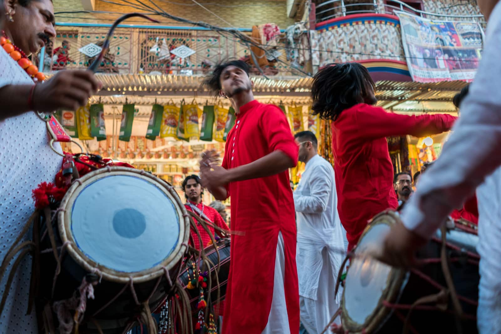 The Urs of Lal Shahbaz Qalandar in Sehwan, Pakistan - Boy in red dancing to drums outside the shrine - Lost With Purpose travel blog