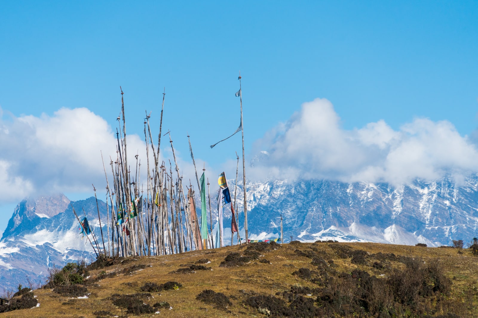 Photos of Bhutan - Prayer flags in front of snowy mountains on the Druk Path - Lost With Purpose travel blog