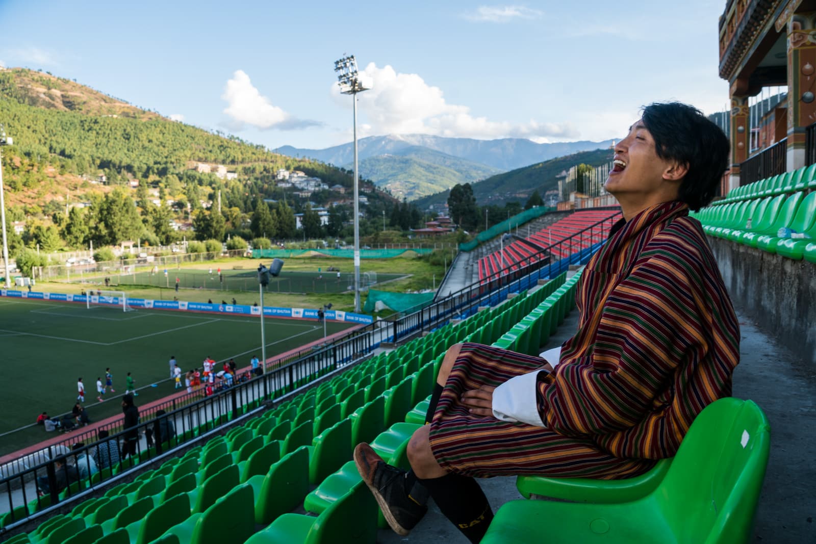 Photos of Bhutan - Tour guide Karma laughing in a football stadium in Thimphu - Lost With Purpose travel blog