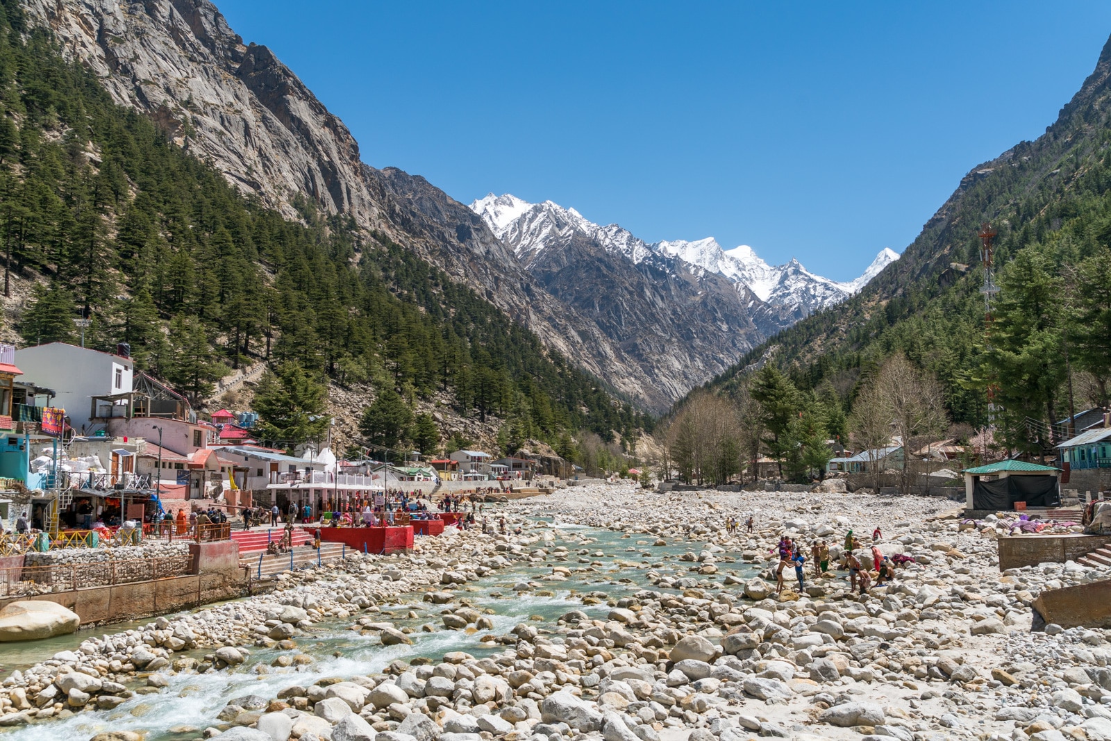 Bhagirathi River flowing through Gangotri town with pilgrims washing in the water