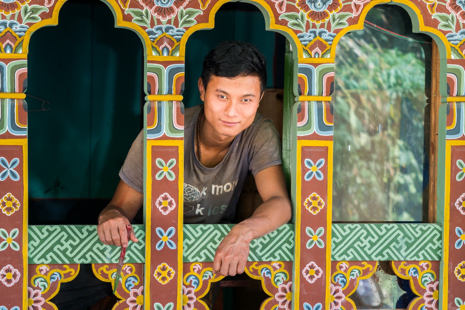 Stunning photos of Bhutan - Boy standing in a traditionally painted Bhutanese window - Lost With Purpose travel blog