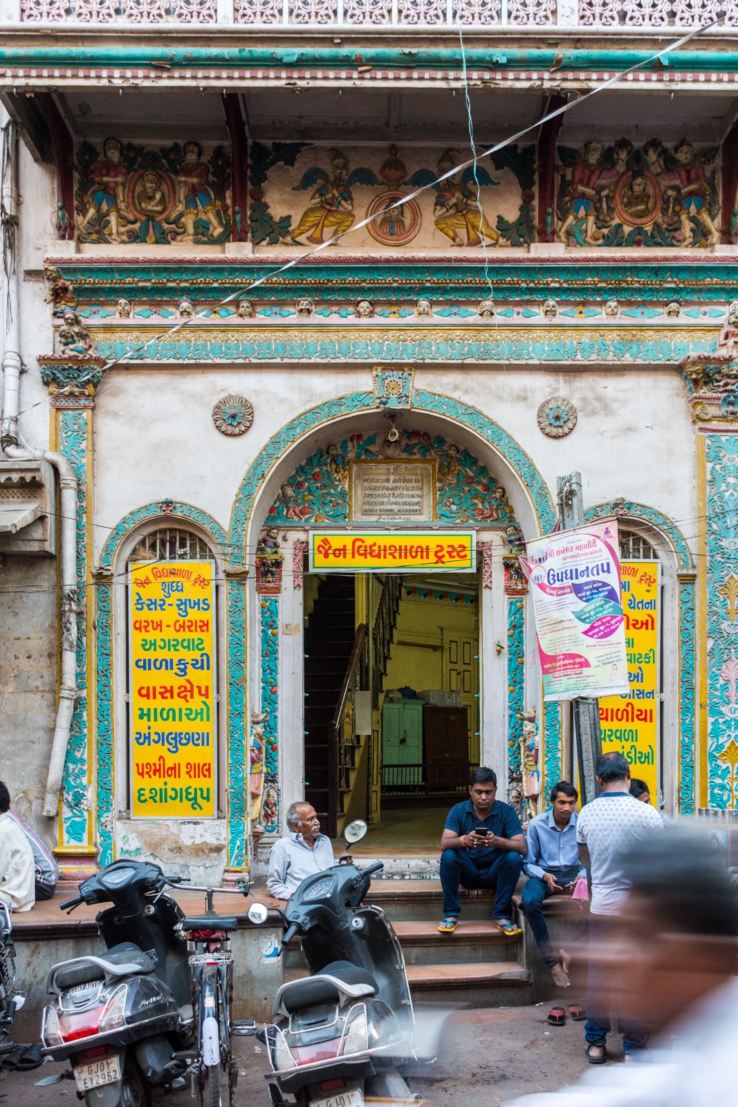 Men sitting outside a colorful traditional building in Ahmedabad